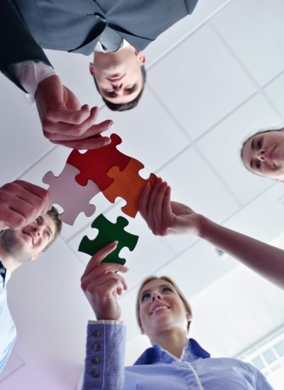 Group of business people assembling jigsaw puzzle Group of business people assembling jigsaw puzzle and represent team support and help concept