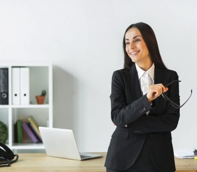 smiling-young-businesswoman-standing-front-office-desk