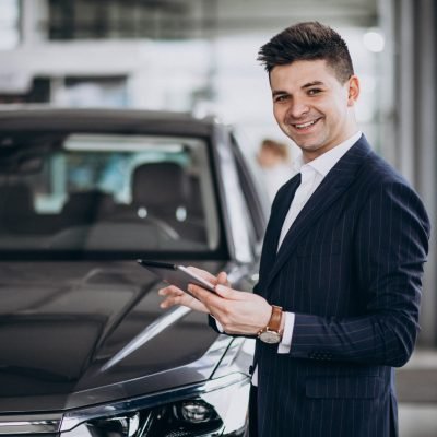 Young handsome business man in a car showrrom
